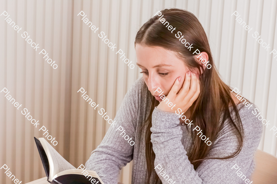 A girl sitting and reading a book stock photo with image ID: 0e613590-d26e-4ca2-ba35-c9ac306d202c