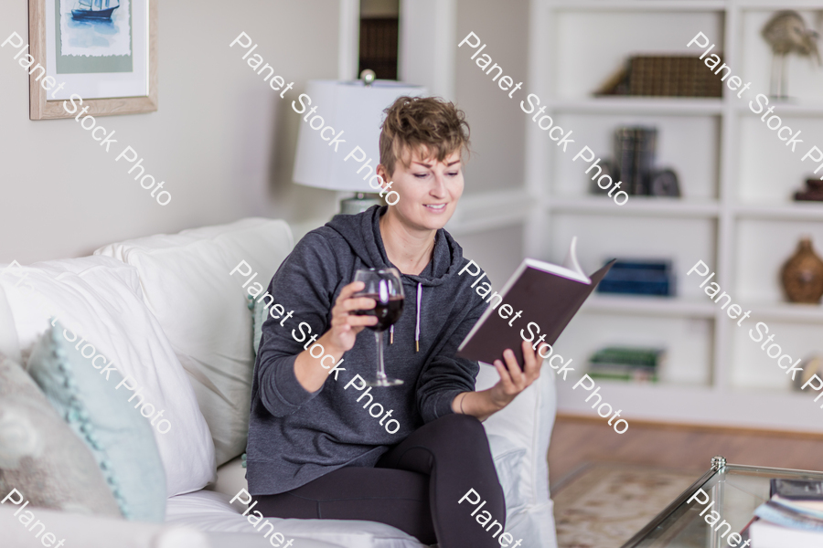 A young lady sitting on the couch stock photo with image ID: 70bd9062-91fe-4546-a1f9-afefce2126aa