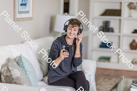 A young lady sitting on the couch stock photo with image ID: 1cfc7a46-fd6b-4350-9fe6-d47a0672c455