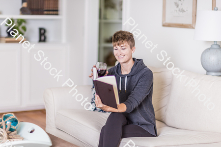 A young lady sitting on the couch stock photo with image ID: 51bf122f-5636-42e4-8bbc-f907ce350556