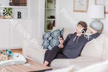 A young lady sitting on the couch stock photo with image ID: 74fd83cb-d3e0-4506-992a-d84a1351aed4