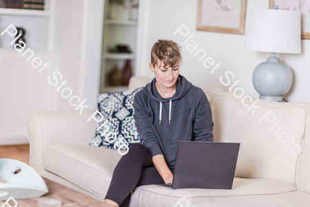 A young lady sitting on the couch stock photo with image ID: 7e0af2e6-8d0d-498a-87cc-5b9772c1deb7