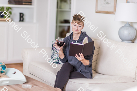 A young lady sitting on the couch stock photo with image ID: adba4287-c858-49ad-8334-b6ad29552061