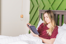 A young woman reading in bed