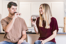A young couple sitting and enjoying red wine